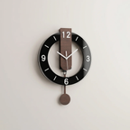 Modern wall clock with black face and wooden pendulum on a light gray background