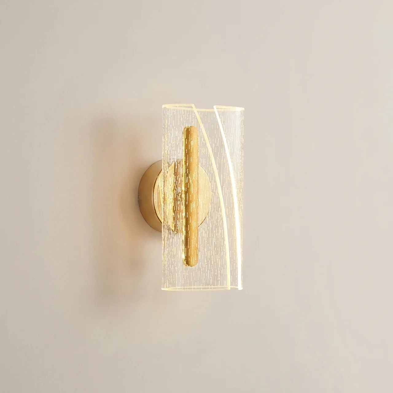 Gold wall sconce with glass shade on a neutral wall