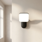 Modern wall lamp with square light fixture on a neutral wall.