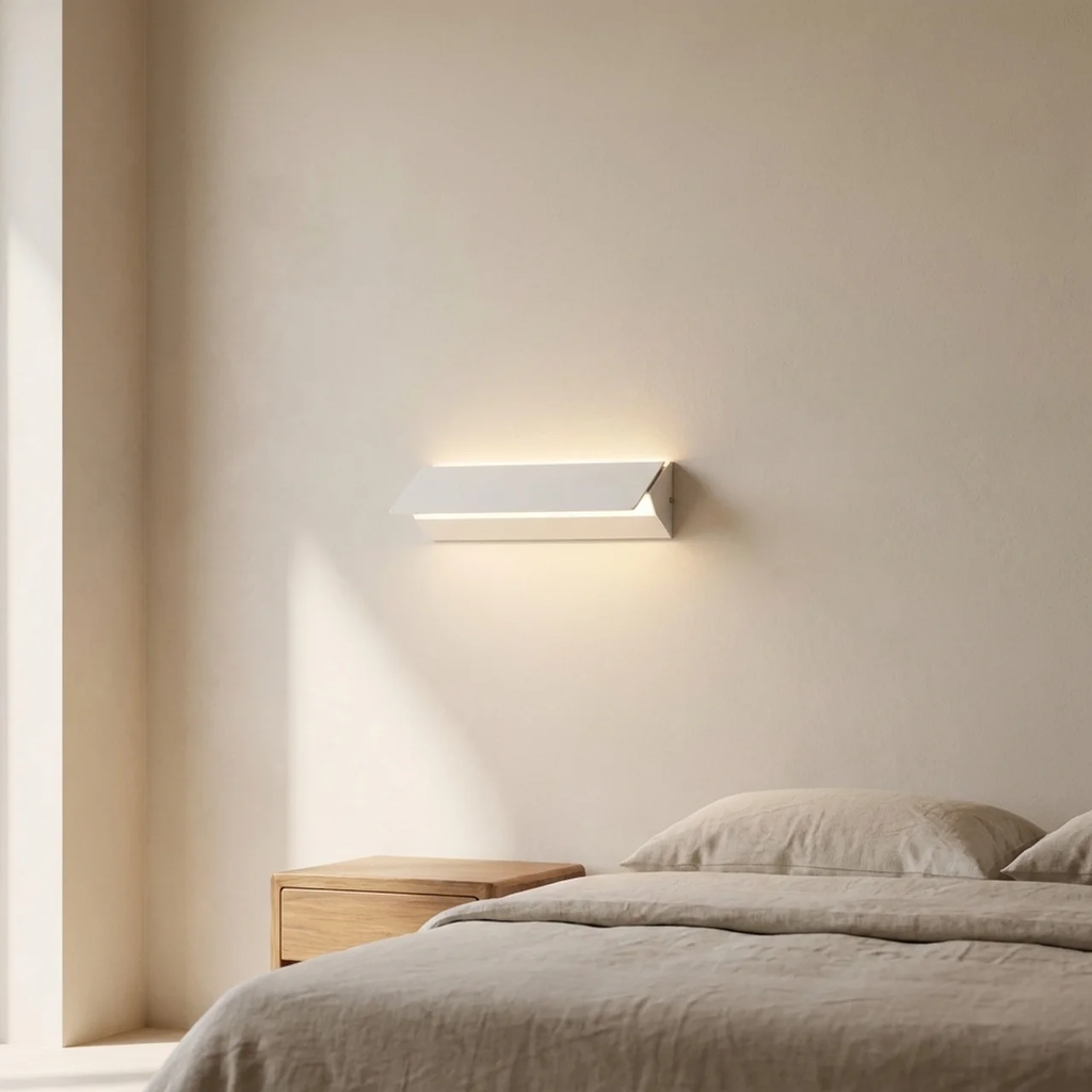 Modern wall light fixture on a neutral wall above a bed