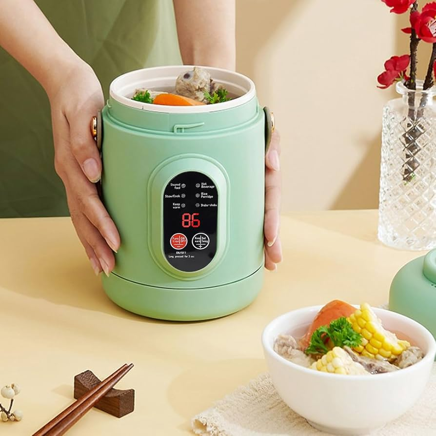 Green electric rice cooker with digital display held by a hand on a light-colored surface.