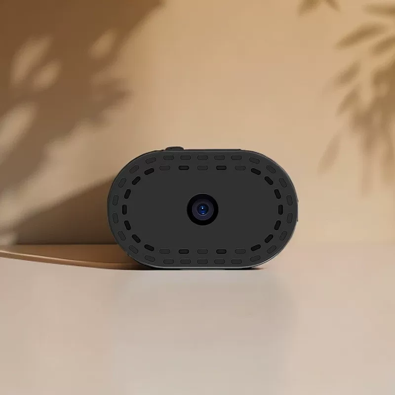 Black camera on a beige surface with a neutral background