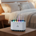 White humidifier with colorful lights on a wooden nightstand in a bedroom setting.