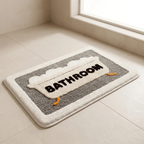 Gray bath mat with 'Bathroom' text on a tiled floor