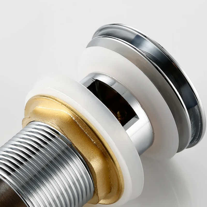 Close-up of a plumbing drain trap with gold and silver components on a white background