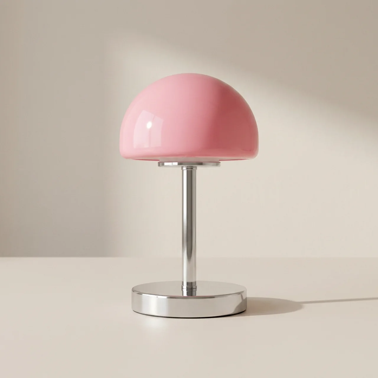 Pink table lamp with a metallic base on a neutral background