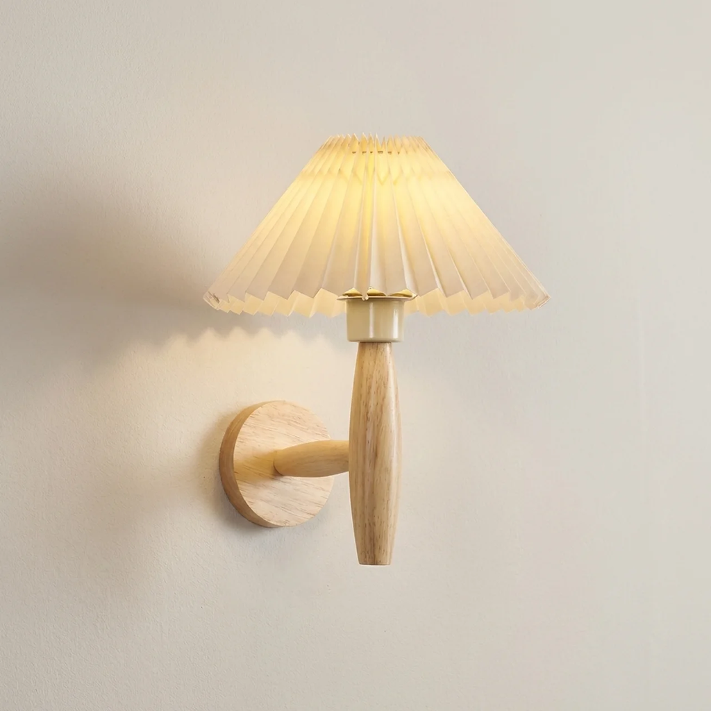 Wall-mounted lamp with pleated glass shade on a plain wall