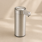 Stainless steel soap dispenser on a beige background