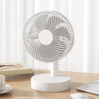 White desk fan on a wooden surface with a white curtain background