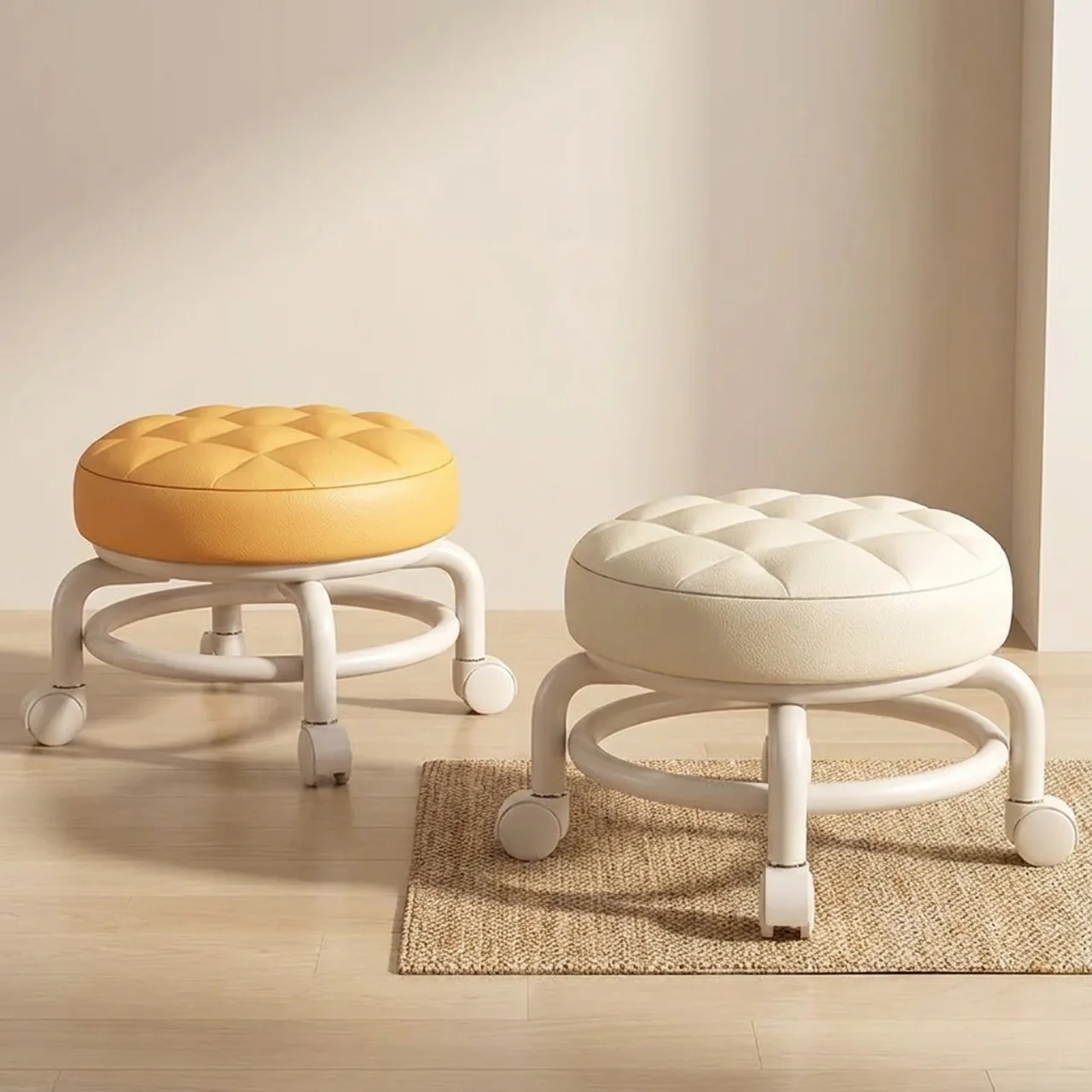 Two round stools with cushioned tops on wheels in a room setting.