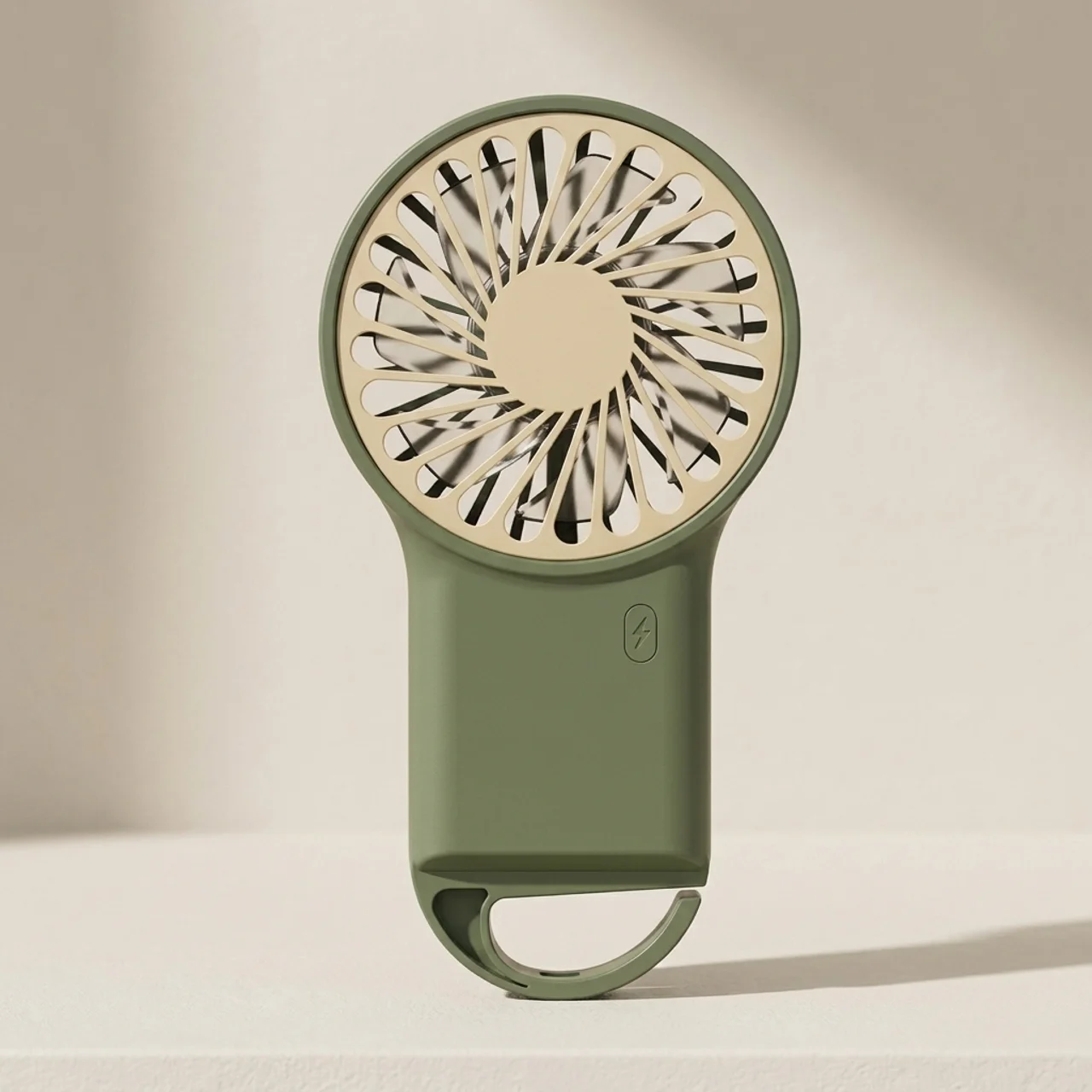 Green handheld fan with beige center on a beige background