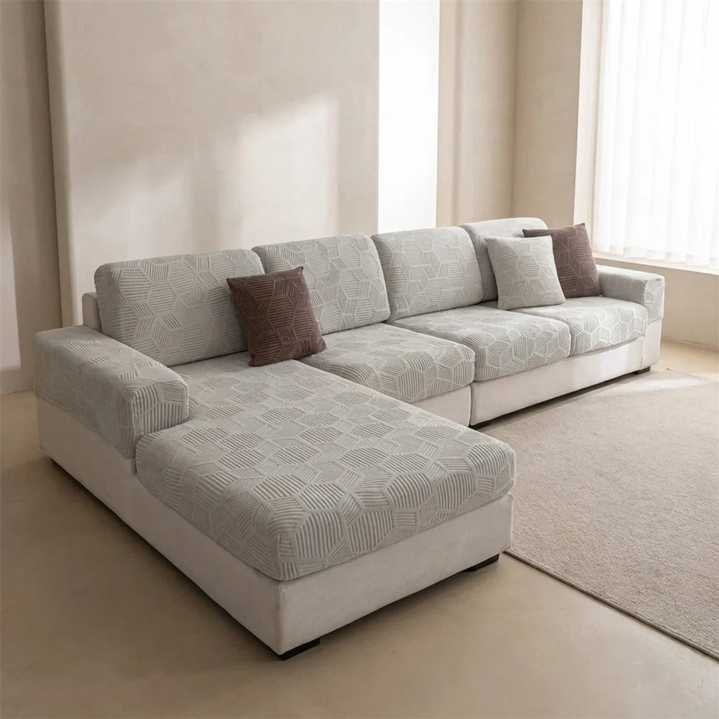 Gray sectional sofa with patterned cushions in a minimalistic living room.