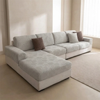 Gray sectional sofa with patterned cushions in a minimalistic living room.