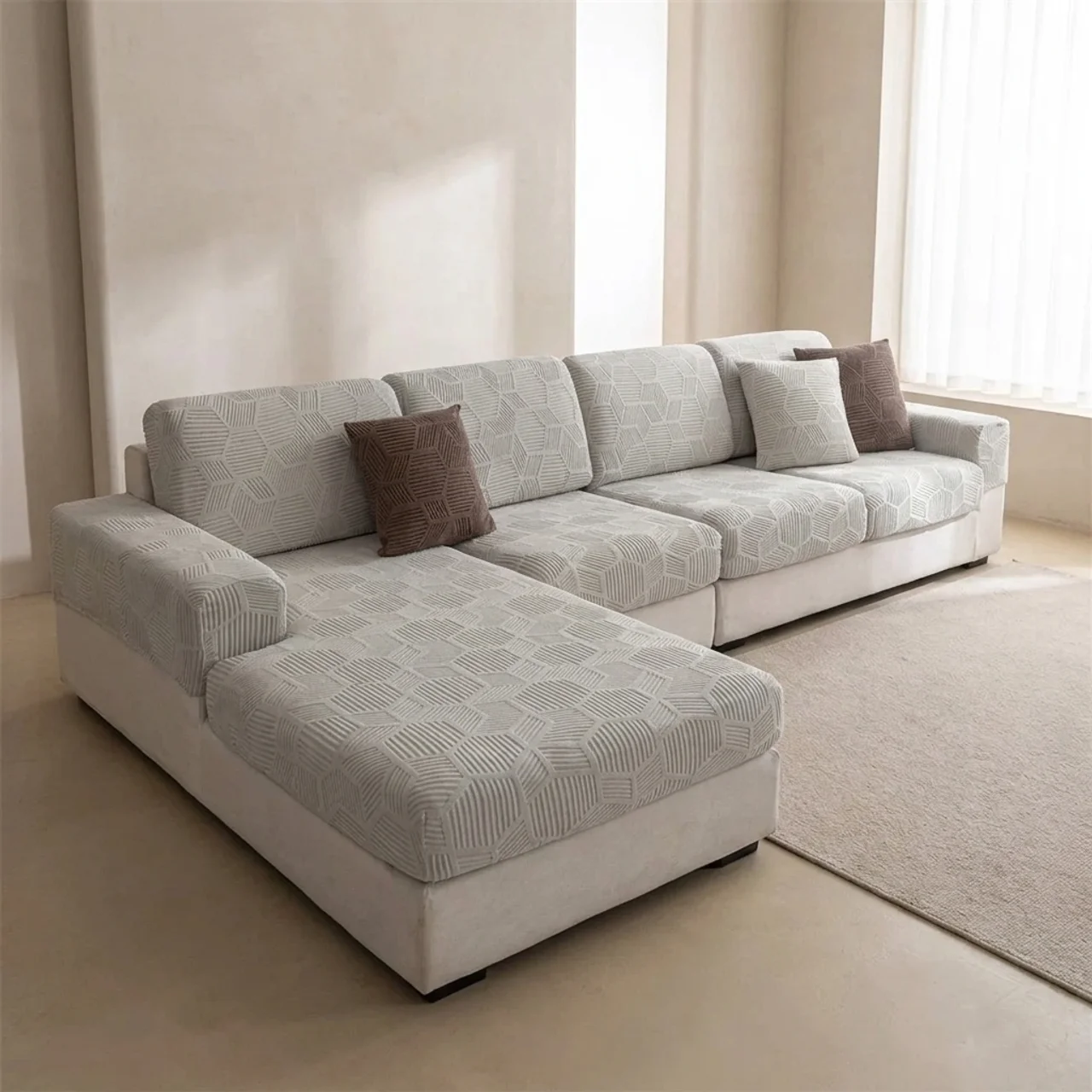Gray sectional sofa with patterned cushions in a minimalistic living room.