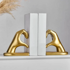 Gold hand-shaped bookends on white books against a light gray background