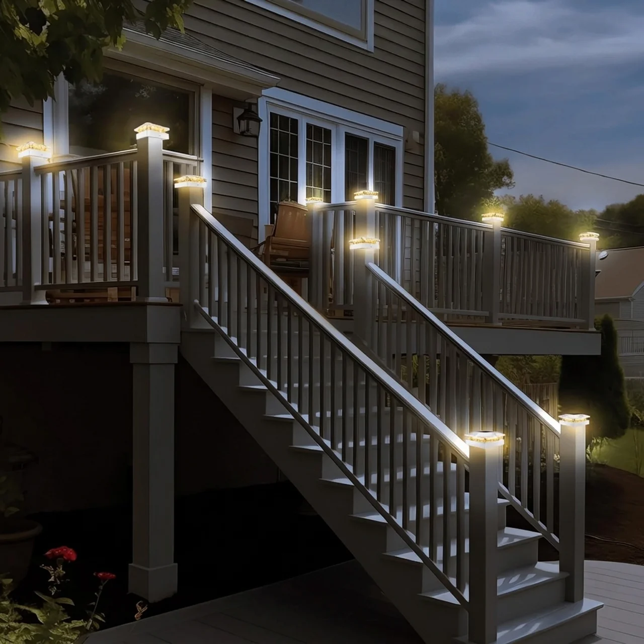 Staircase leading to a house with string lights on the railings at night.