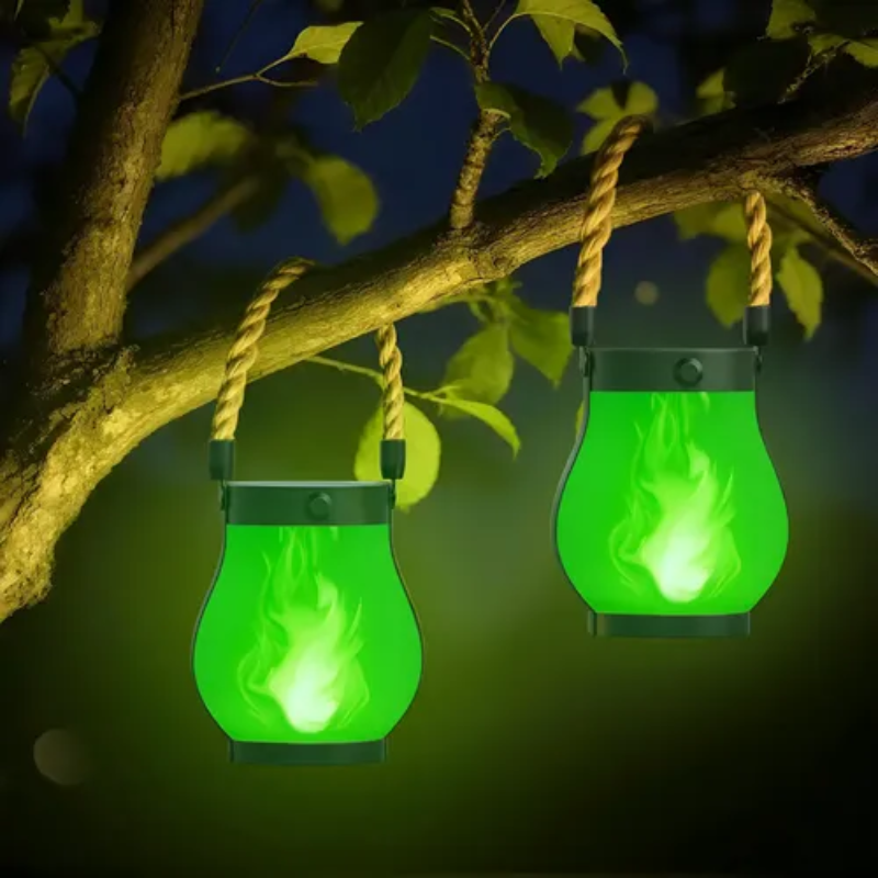Two green lanterns hanging from a tree branch at night.