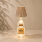 Hennessy VSOP bottle lamp with pleated shade on a beige background