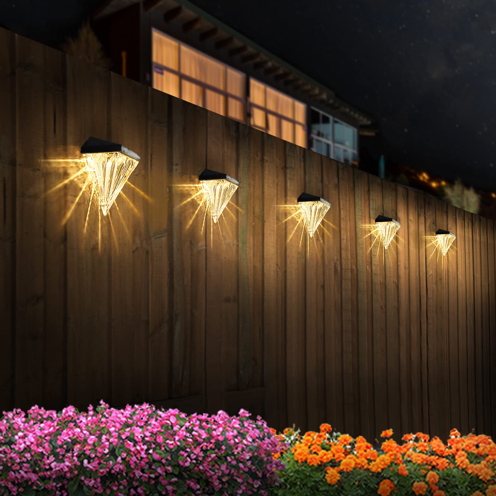 Solar lights on a wooden fence with flowers in the foreground