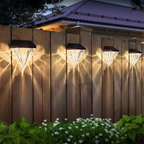 Solar lights on a wooden fence with a house in the background