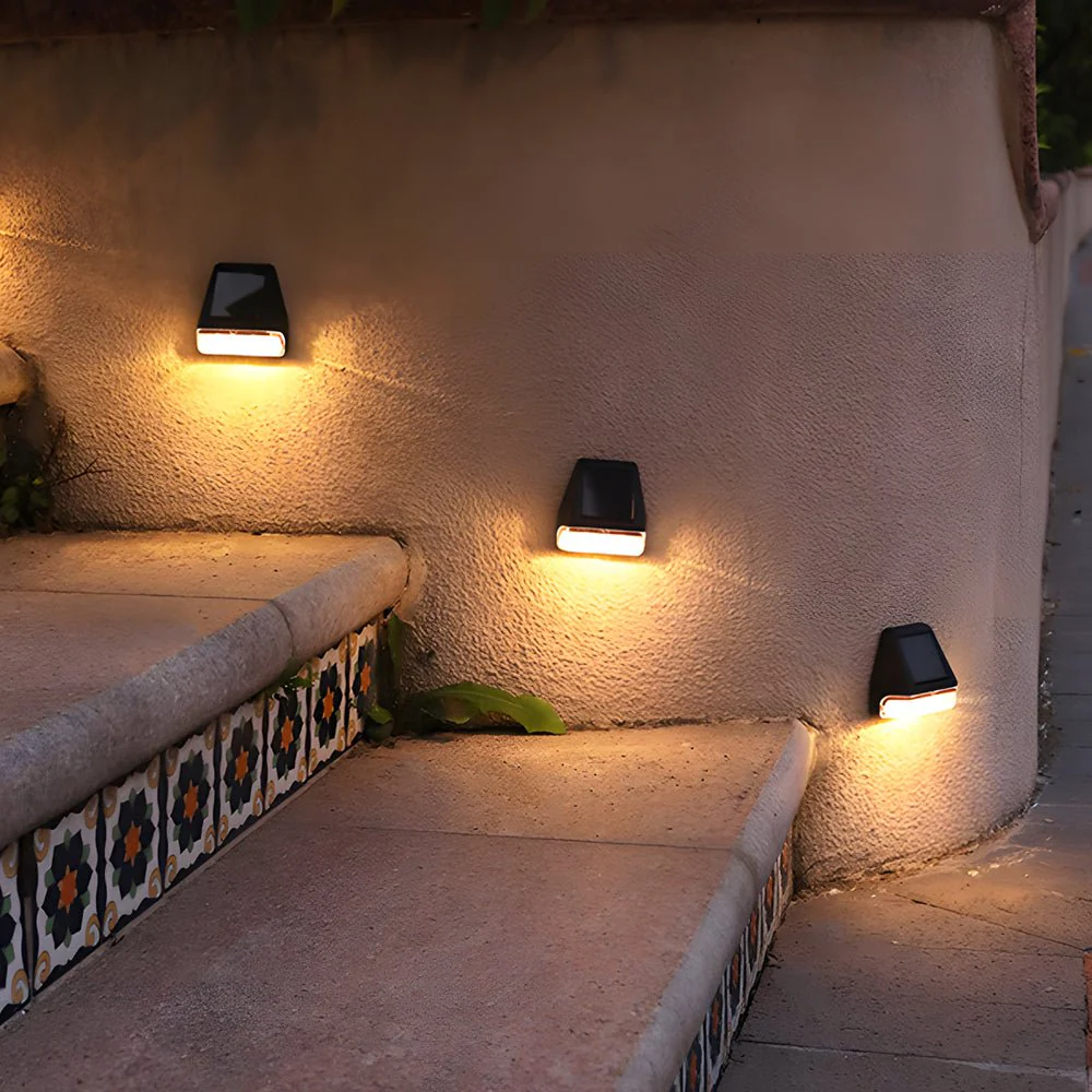 Three outdoor wall lights on a textured wall with a decorative bench below.