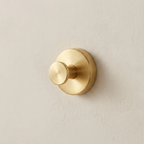 Gold wall hook on a beige wall