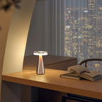 Table lamp on a desk with a cityscape view at night