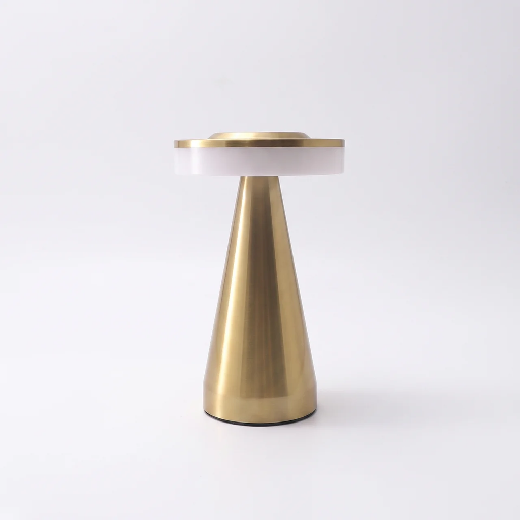 A modern table lamp with a tapered brushed brass base, a white cylindrical shade, and a brushed brass top rim, photographed on a seamless white background.