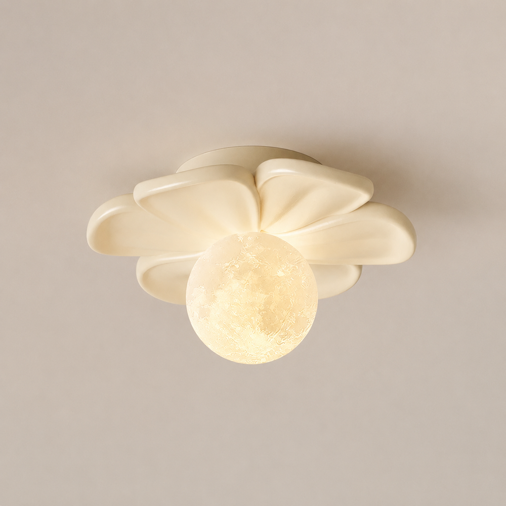A modern ceiling light fixture with a flower-like cream shade and a glowing spherical moon-shaped bulb, shown against a plain beige wall.