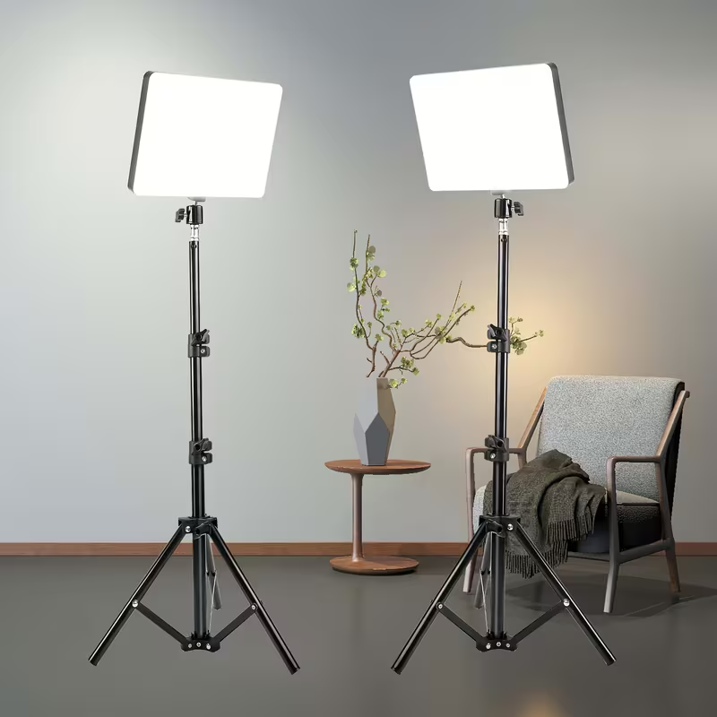 Two studio lights on tripods in a room with a chair and small table.