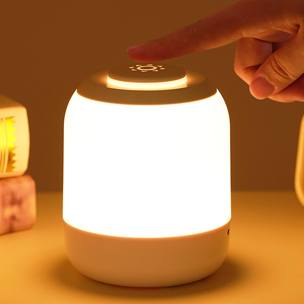 Hand pressing a button on a glowing night light with a warm glow.