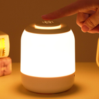 Hand pressing a button on a glowing night light with a warm glow.