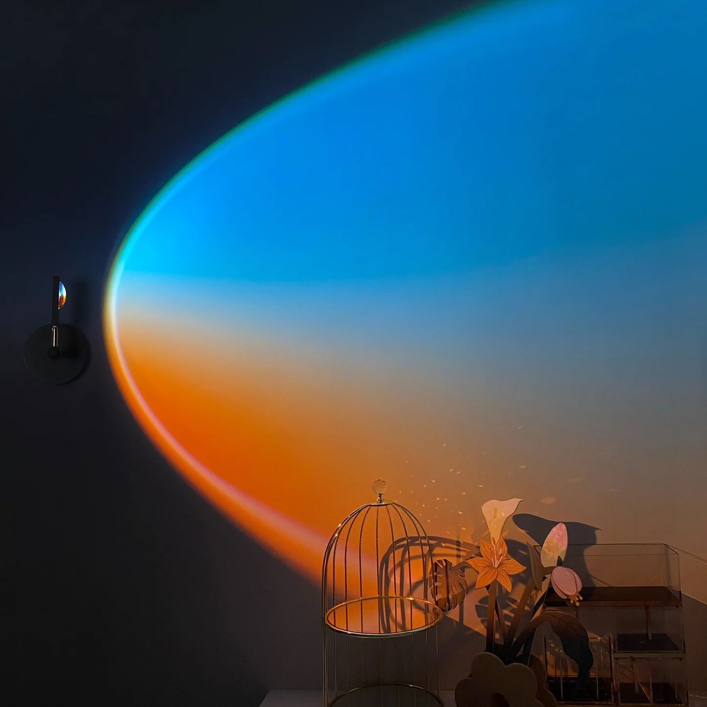 Room interior with a gradient wall color transitioning from blue to orange, decorative items on a table.