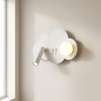 A white cloud-shaped wall sconce with a built-in spotlight and a round glowing bulb, mounted on a beige wall next to a window.