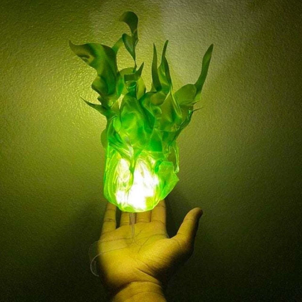Hand holding a green glowing dragon-shaped object against a dark background