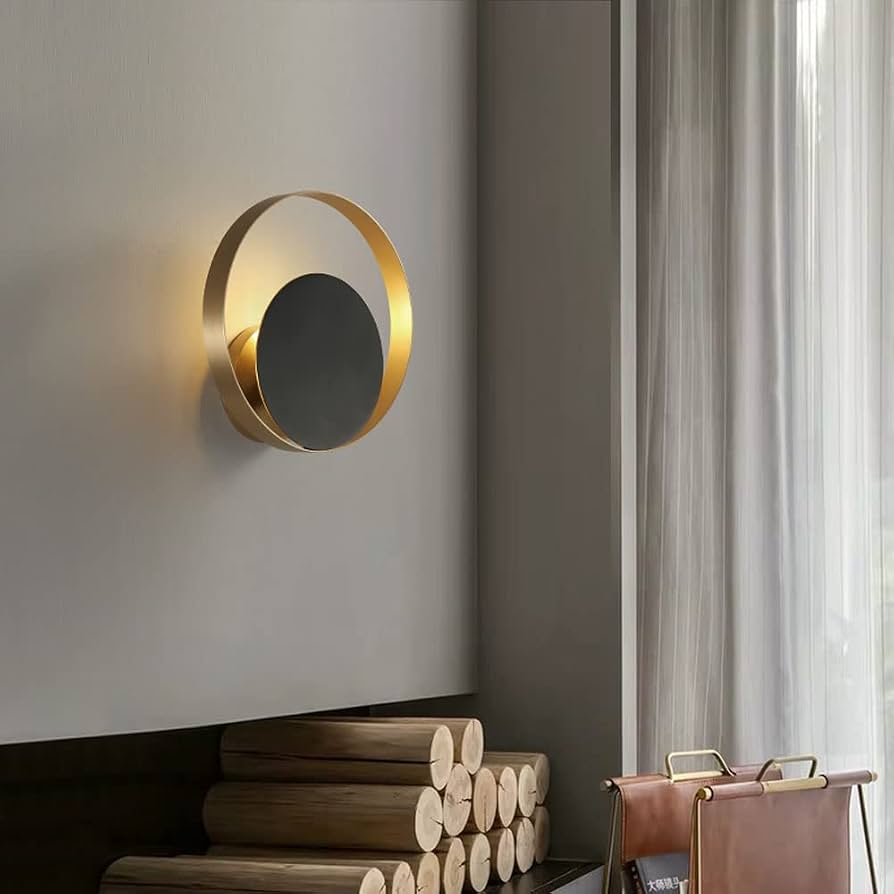 Modern wall-mounted light fixture on a neutral wall with a chair and decorative items in the foreground.