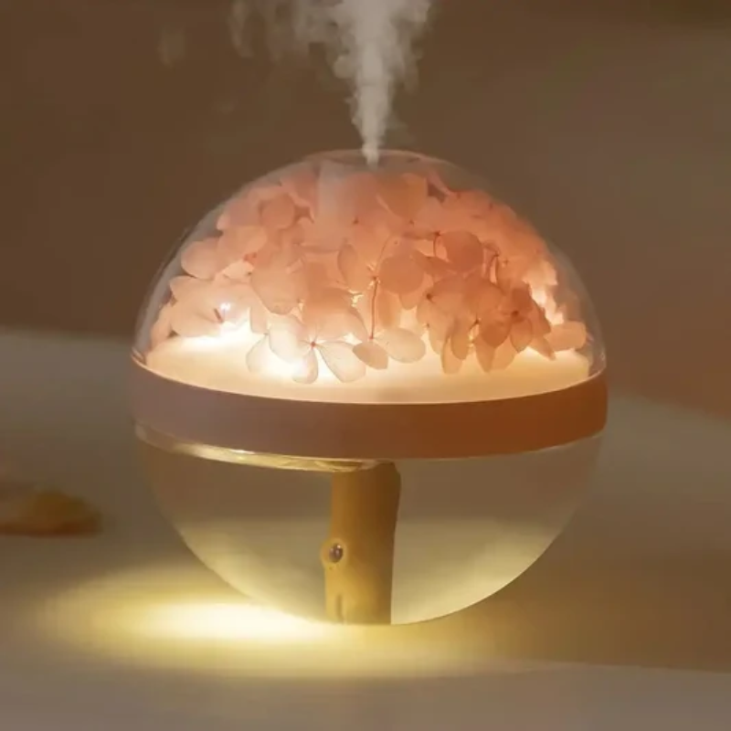 Humidifier with pink flowers inside emitting steam on a dark background