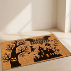 A rectangular coir doormat with a Halloween design, featuring a jack-o'-lantern tree, a witch riding a broomstick, a haunted house, bats, and the words 'Happy Halloween' in black silhouettes on a natural tan background.