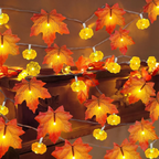 Warm white LED string lights featuring realistic orange and red autumn maple leaves and glowing pumpkin-shaped bulbs, draped over a dark wooden surface.