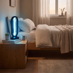 A modern oval LED night light with a black frame and glowing blue light, styled on a wooden bedside table next to a bed in a softly lit bedroom.