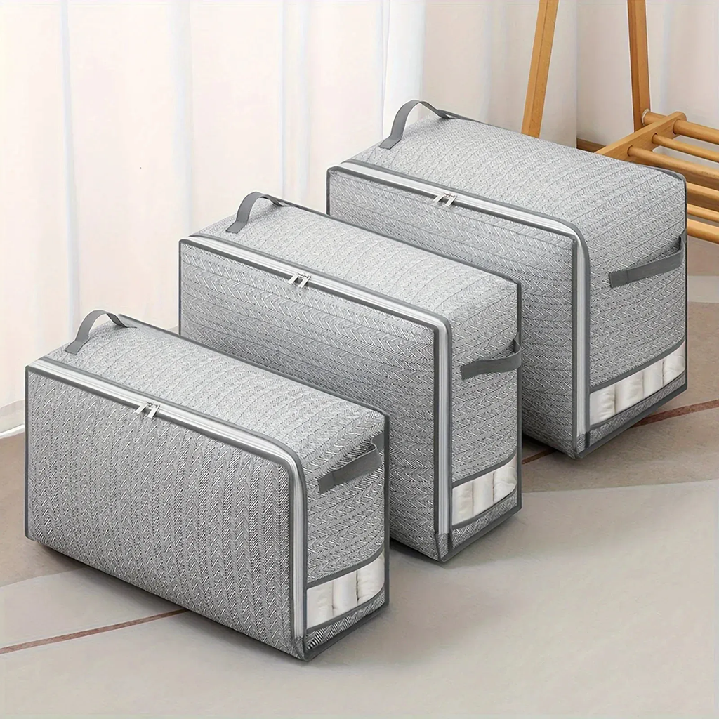 Set of gray storage bags with zippers on a light wooden floor.