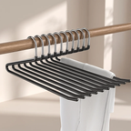 A set of black metal hangers with silver hooks, shown hanging from a wooden closet rod with a white garment draped over them.