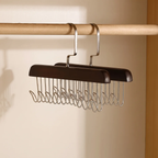 A pair of dark brown wooden hangers with silver metal wire hooks, hanging from a wooden closet rod against a beige wall.