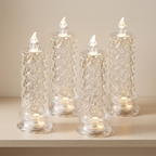 Four clear glass taper candle holders with a textured, diamond-cut pattern and built-in warm white LED lights, arranged on a light wood surface against a neutral beige background.