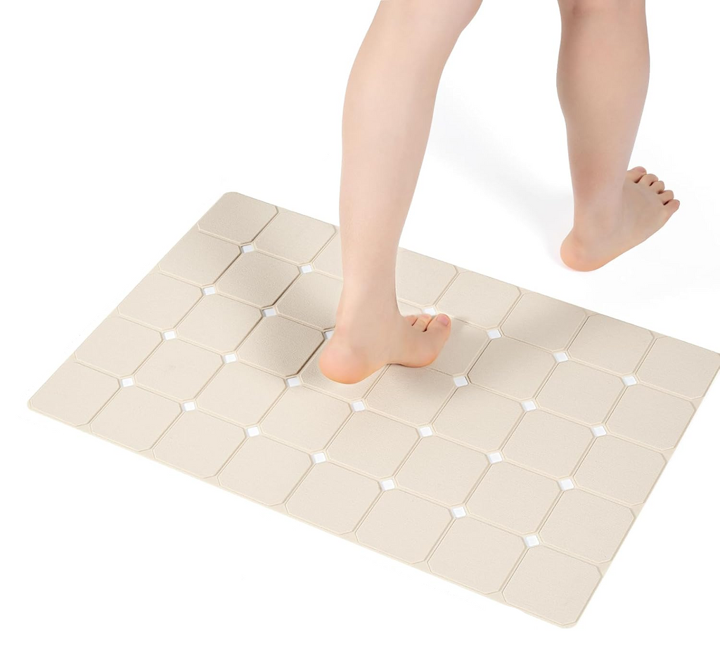 A beige shower mat shown on a white background with a person's feet stepping on it. Black text at the top reads 'GREAT SIZE, FIT FOR MOST OF SHOWER & TUB' with dimension lines indicating 17.