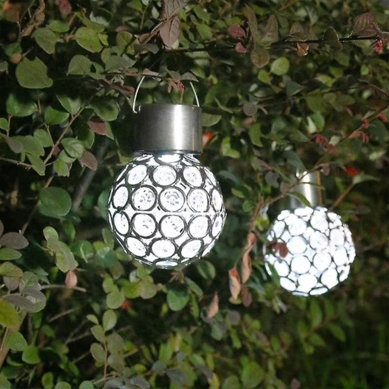 Solar-powered decorative lights hanging among green leaves