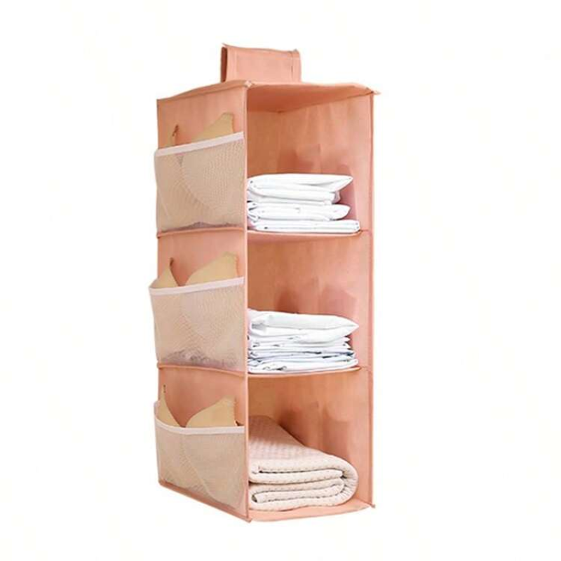 A peach-colored fabric hanging organizer with four tiers of mesh side pockets and three open shelves, shown holding folded white towels and sheets against a plain white background.