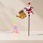 A festive Christmas garden stake decoration featuring a Santa Claus figure holding a gold watering can that casts colorful LED fairy lights downward, set against a warm beige background.