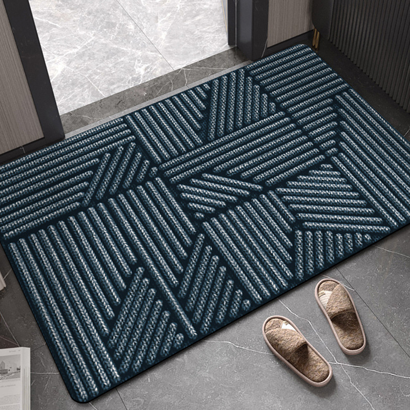 Green geometric patterned rug on a gray floor with slippers nearby.