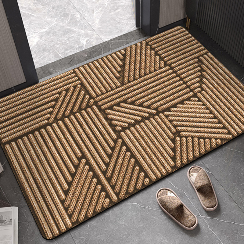 Geometric patterned doormat on a gray floor with slippers nearby